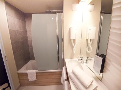 克莱蒙费朗克莱蒙费朗市中心钟楼酒店的带浴缸、水槽和淋浴的浴室