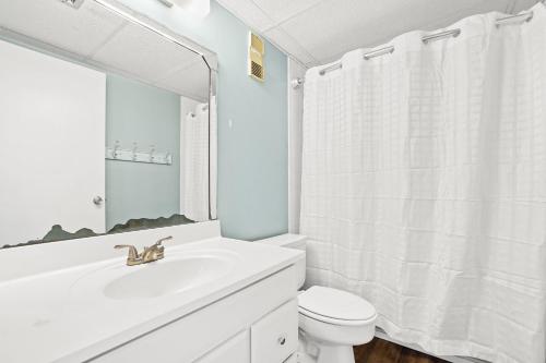 巴拿马城海滩Moondrifter Beach Resort by Panhandle Getaways的白色的浴室设有水槽和卫生间。
