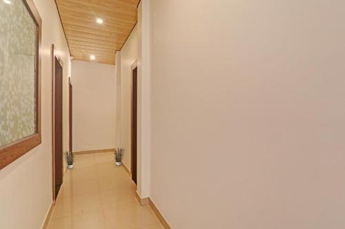 戈勒克布尔OYO Flagship R V Palce的走廊上设有白色的墙壁和墙上的绘画作品