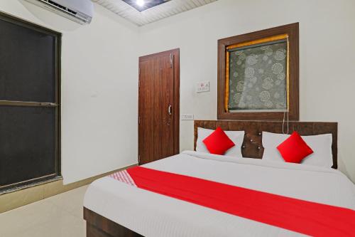 戈勒克布尔OYO Flagship R V Palce的一间卧室配有一张带红色枕头的大床