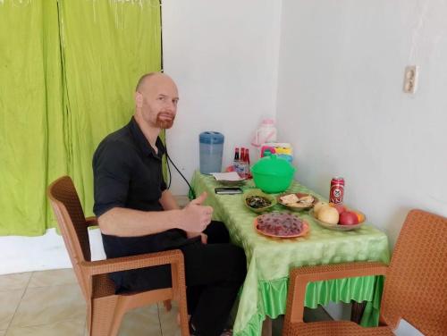 索龙彭金阿帕恩科菲亚度假屋的坐在桌子上的人,用绿色的桌布