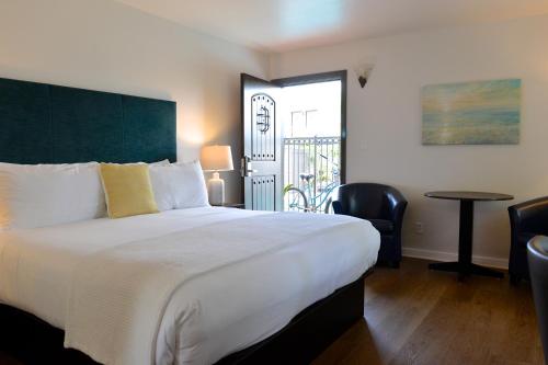 圣地亚哥科罗纳多皇冠城旅馆的卧室配有一张白色的大床和一张桌子
