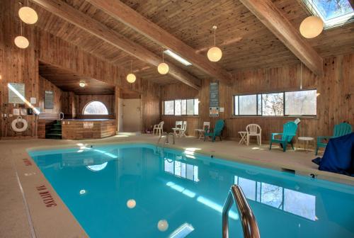 榉木山Cedar Village Condominiums的一座大型游泳池,位于一栋带木制天花板的建筑内