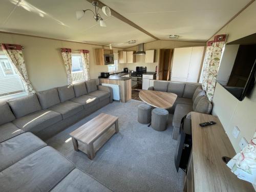 塔特舍尔87 Lancaster Crescent的客厅配有大沙发和桌子
