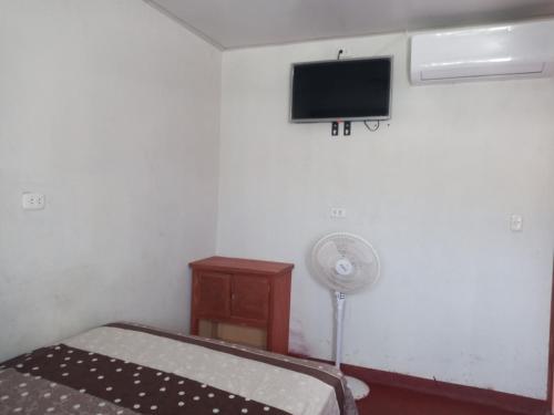 El ÑuroMARANATHA的卧室配有一张床,墙上配有电视。