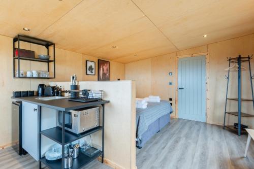 圣安德鲁斯Rustic Cabins, sea views from rewilded farm的一间设有厨房和一张位于客房内的床的房间