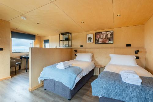 圣安德鲁斯Rustic Cabins, sea views from rewilded farm的一间卧室配有两张床、一张桌子和一把椅子