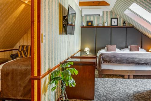 莱维采金鹰酒店的一间卧室配有一张床和一张植物桌子