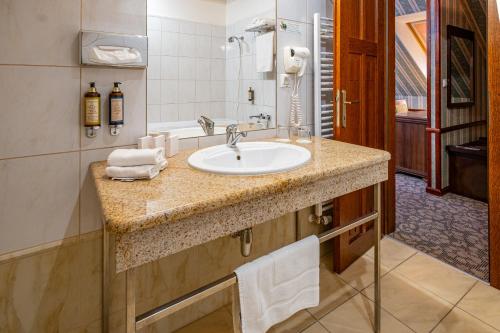 莱维采金鹰酒店的浴室配有盥洗盆和浴缸。