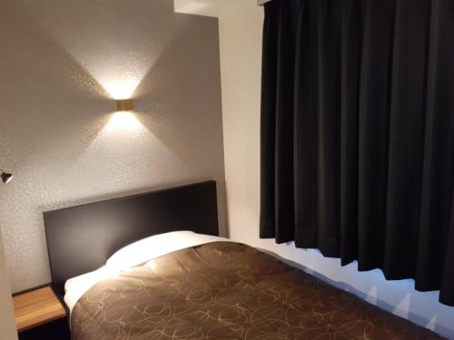 伊万里市ＨＯＴＥＬ ＷＩＮ - Vacation STAY 72249v的卧室配有一张床,墙上有灯