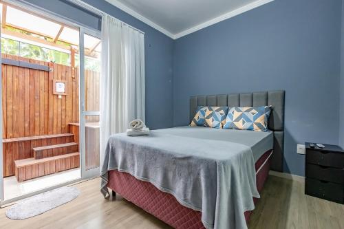 巴拉奈里奥-坎布里乌Apartamento 2 quartos com Spá Expocentro Praias的一间卧室配有一张蓝色墙壁的床和一扇窗户
