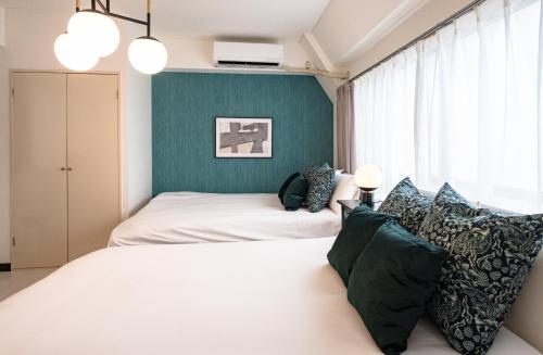 东京Princet Shinjuku Building - Vacation STAY 15549的一间卧室设有两张床和绿色的墙壁