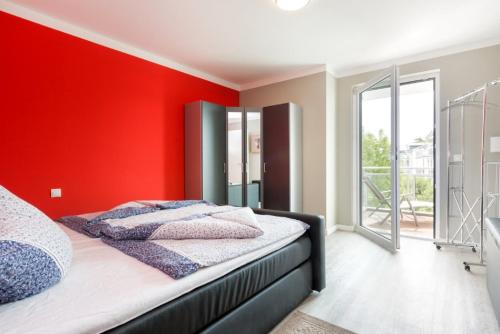 朱列斯拉赫Ferienwohnung Strandläufer的卧室设有红色的墙壁和一张床