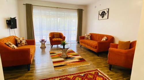 恩德培Nimaro Courts的客厅配有橙色沙发和地毯。