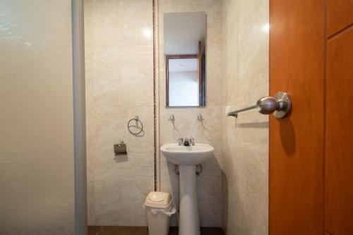 伊洛Hospedaje Arenas del Mar的一间带水槽、镜子和卫生间的浴室