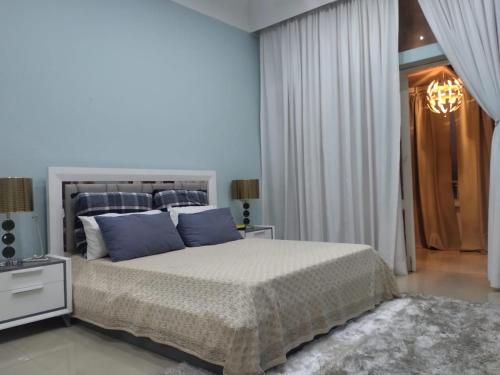 罗安达A vista perfeita的一间卧室配有一张带蓝色枕头的大床