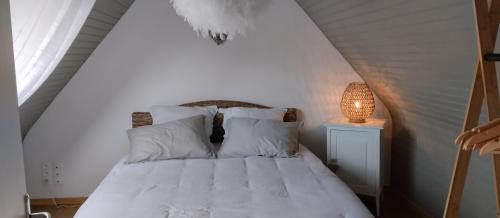 劳恩尼克TI-ARMOR的一间卧室配有一张带白色床单和一盏灯的床。