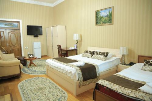 杜尚别ALMOS的一间酒店客房,设有两张床和电视