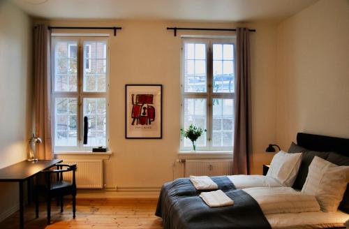 欧登塞Aparthotel Mageløs 12的卧室配有一张床、一张书桌和窗户。