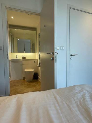 伦敦Luxury en-suite room Olympic Village in shared apartment的一间带一张床的卧室和一间带镜子的浴室