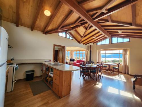 马纳普里Manapouri Holiday Park的一间厨房和一间带木制天花板及桌子的客厅