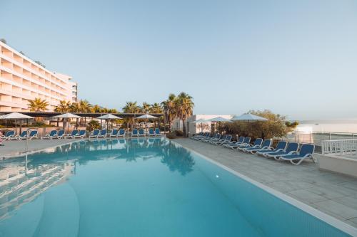 马卡尔斯卡Romana Beach Resort的一个带椅子的大型游泳池和一间酒店