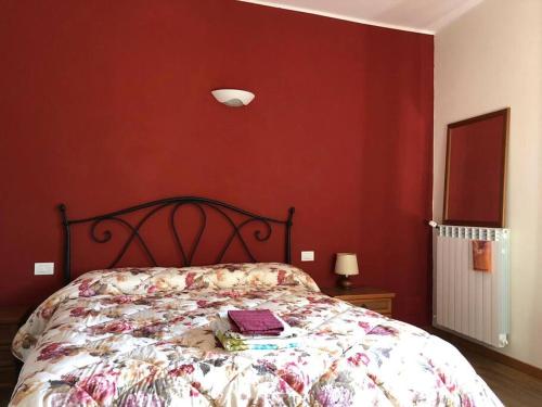 Serralunga di CreaCa' Cuore in Monferrato的一间卧室配有一张红色墙壁的床