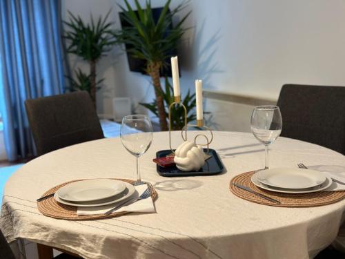 沃特福德Modern Apartment X91 R940的一张带盘子和酒杯的白色桌子