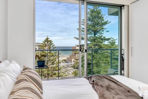 格莱内尔格Waterfront Resort-Style Living at Glenelg Beach的一间卧室设有一张床和一个大窗户