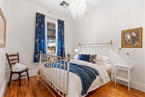 弗里曼特KING44 - King Charming的一间卧室配有一张带蓝色窗帘的床和一把椅子
