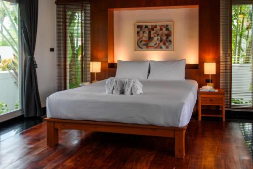 普吉镇Luxurious Residence Rawai的卧室设有一张白色大床和两个窗户。