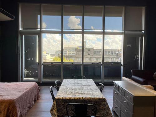 布宜诺斯艾利斯Loft luminoso en Capital Federal的一间卧室设有桌子和大窗户