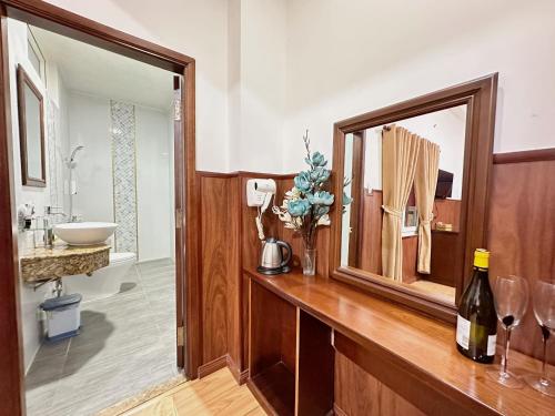 胡志明市Nhat Minh Hotel - Etown and airport的浴室配有带水槽和镜子的木制台面