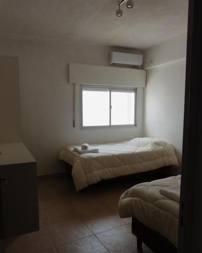 埃斯基纳Habano Apart的一间卧室设有两张床和窗户。