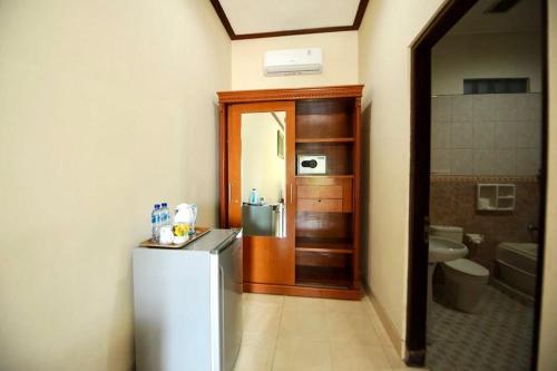 沙努尔Tori Inn的带冰箱的小厨房和浴室