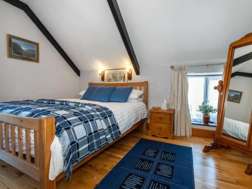 圣大卫Carn Llidi Cottage的一间卧室设有一张大床和一个窗户。