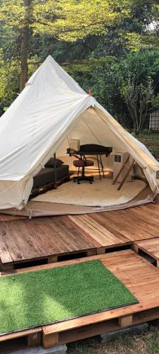 Ban Huai Sok NoiUmarin Glamping Resort的木甲板上的帐篷,配有野餐桌