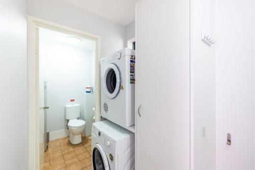 尼尔森湾Nelson Bay Breeze Apartment, 29,1 Trafalgar Street - Air conditioned unit with Linen supplied, complex pool and spa的一间带洗衣机和卫生间的浴室