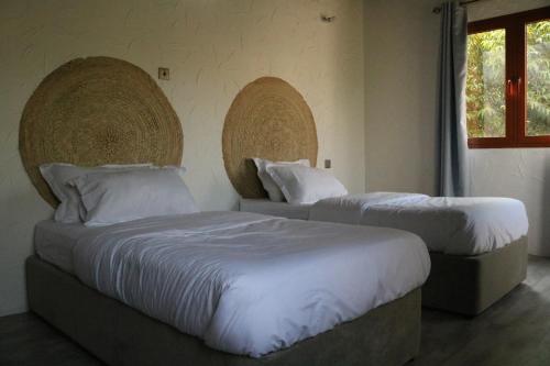 尼兹瓦Riad Nizwa的一间卧室设有两张床和窗户。