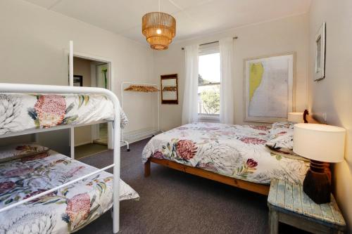帽头镇Muller's Cottage at Hat Head (Pet Friendly)的一间卧室设有两张双层床和一扇窗户。