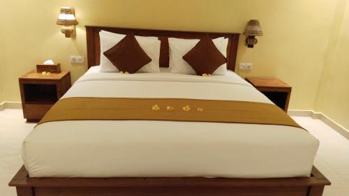 乌布D'Natha Villa Ubud的一张大床,位于带2个床头柜的房间