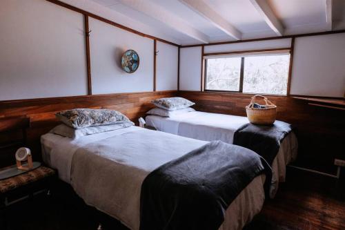 Forest GroveCottage 3 - The Row的客房设有两张床和窗户。