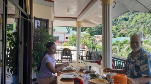 波尔多·格尼拉阿尼努安河滨住宿加早餐旅馆的坐在餐桌旁吃食物的男人和女人