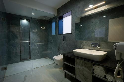 布什格尔Bageecha Resort的一间带水槽、淋浴和卫生间的浴室