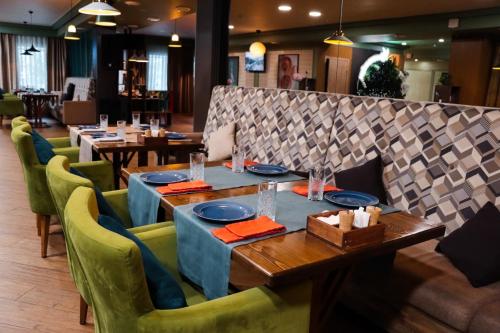 科克舍套Отель KOKSHETAU的用餐室配有桌子和绿色椅子