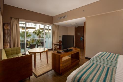 库塔 怡舒乐酒店的酒店客房,配有床和电视