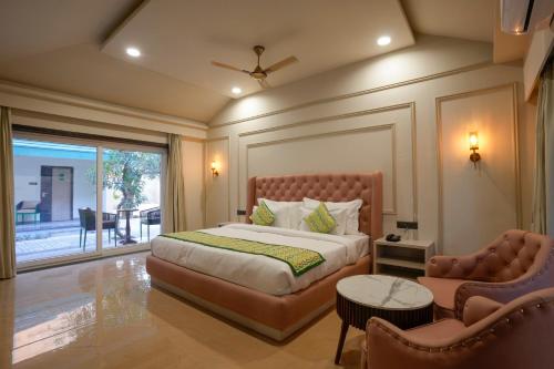 布什格尔Bageecha Resort的卧室配有床、椅子和窗户。
