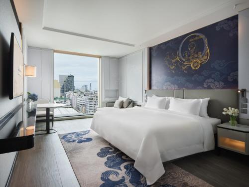 曼谷苏拉翁塞格兰德中心大酒店的卧室设有一张白色大床和大窗户