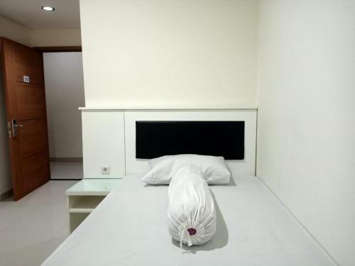 TomohonOYO 93303 Lourdes Blessing Hill的卧室配有白色的床和床头板