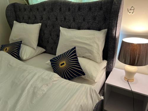 伊斯兰堡Two Bed Apartment F6 netflix wifi ac的一张带白色枕头和黑色床头板的床